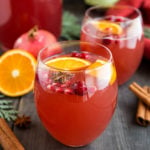 2 glasses of Christmas punch with orange slices and cranberries