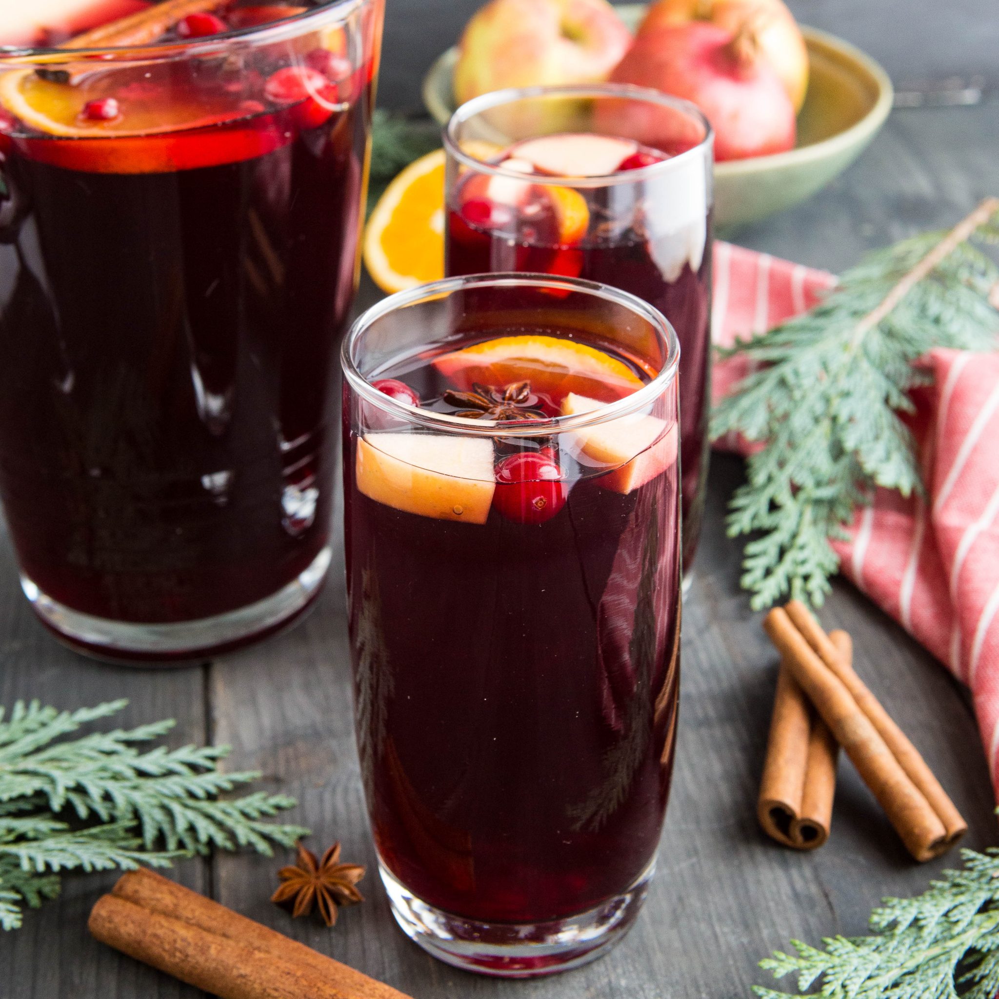 glass and pitcher of apple cranberry sangria