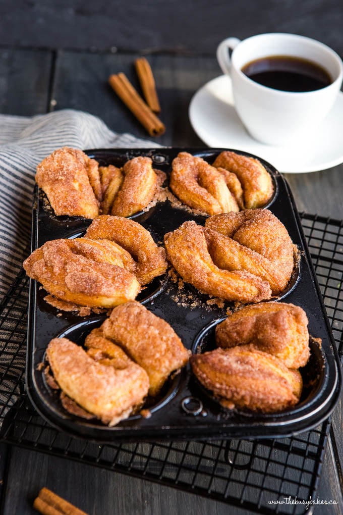 pan of cinnamon sugar twist donuts next to a cup of coffee