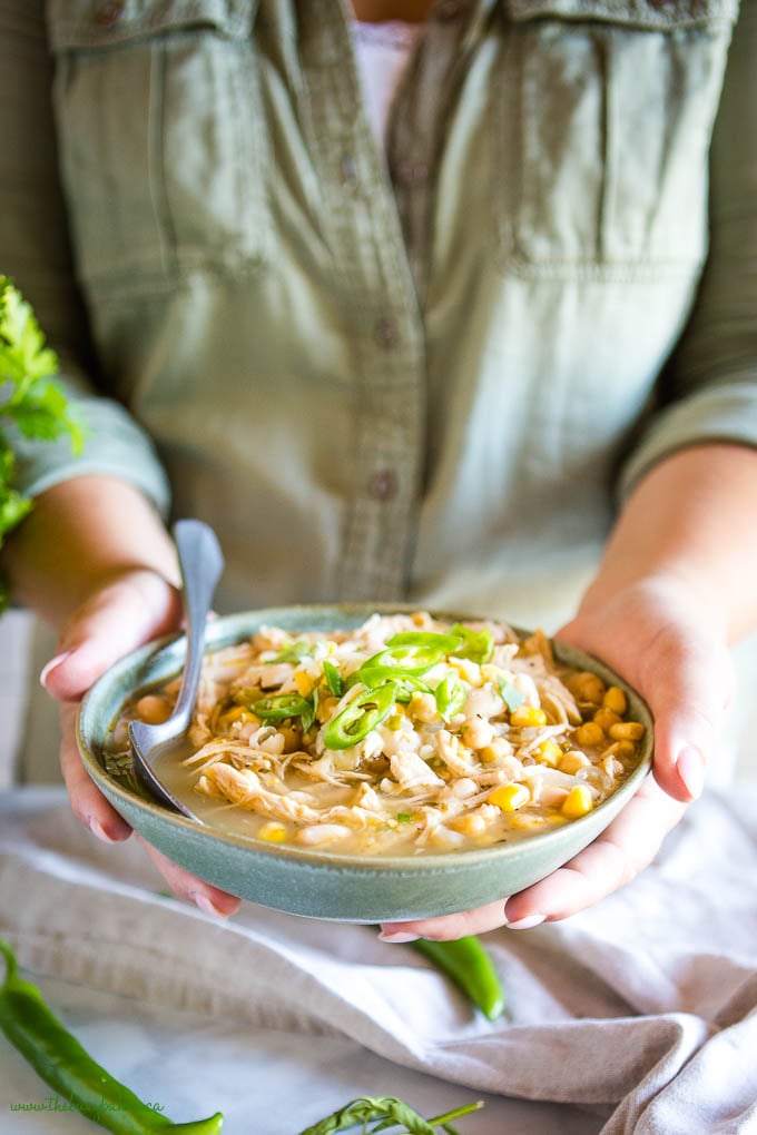 woman holding bowl of white chicken chili
