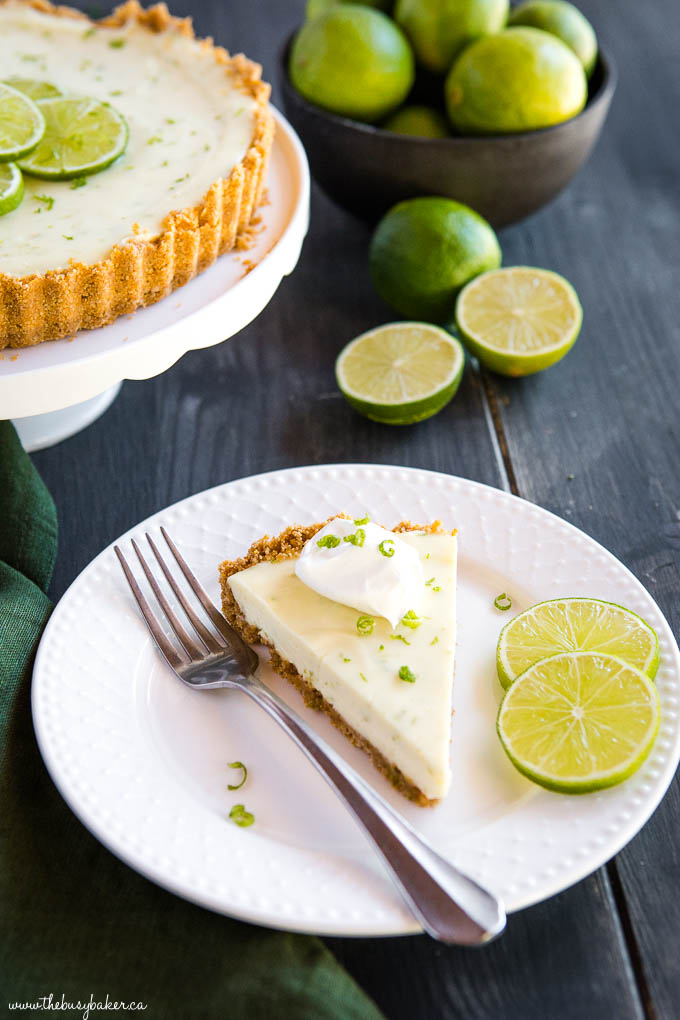 slice of key lime pie on white plate with lime slices