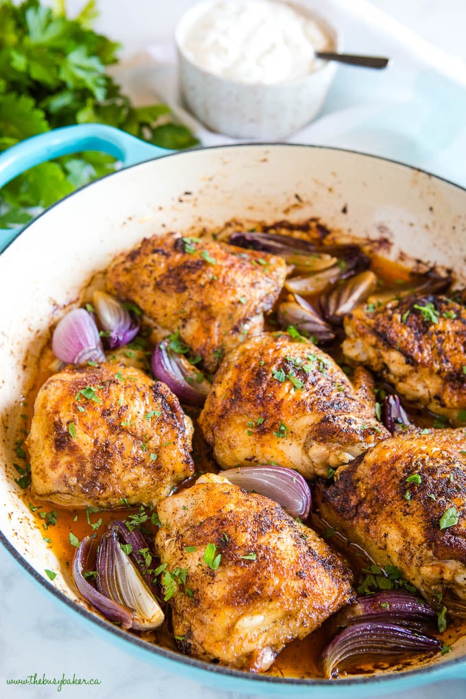 African chicken dinner in blue pan with onions and garlic sauce