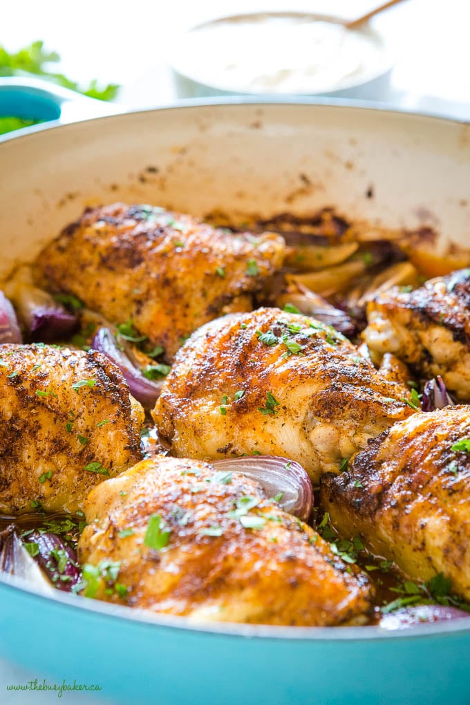 roasted harissa chicken thighs in blue cast iron pan