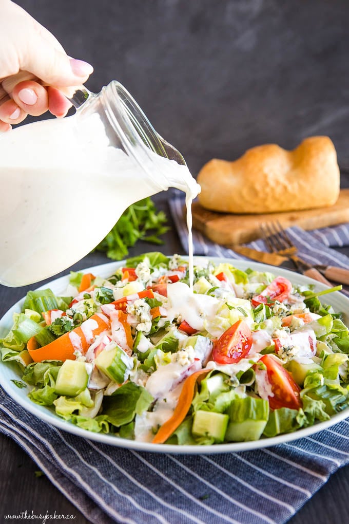 pouring keto blue cheese dressing on garden salad