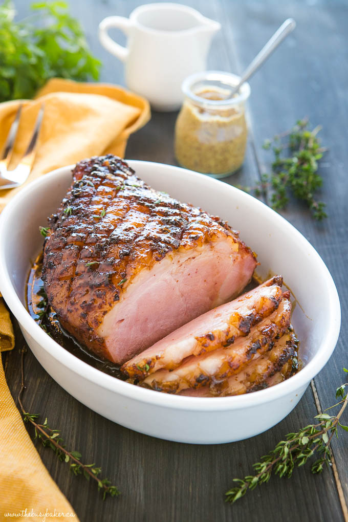 sliced maple glazed ham in white serving dish