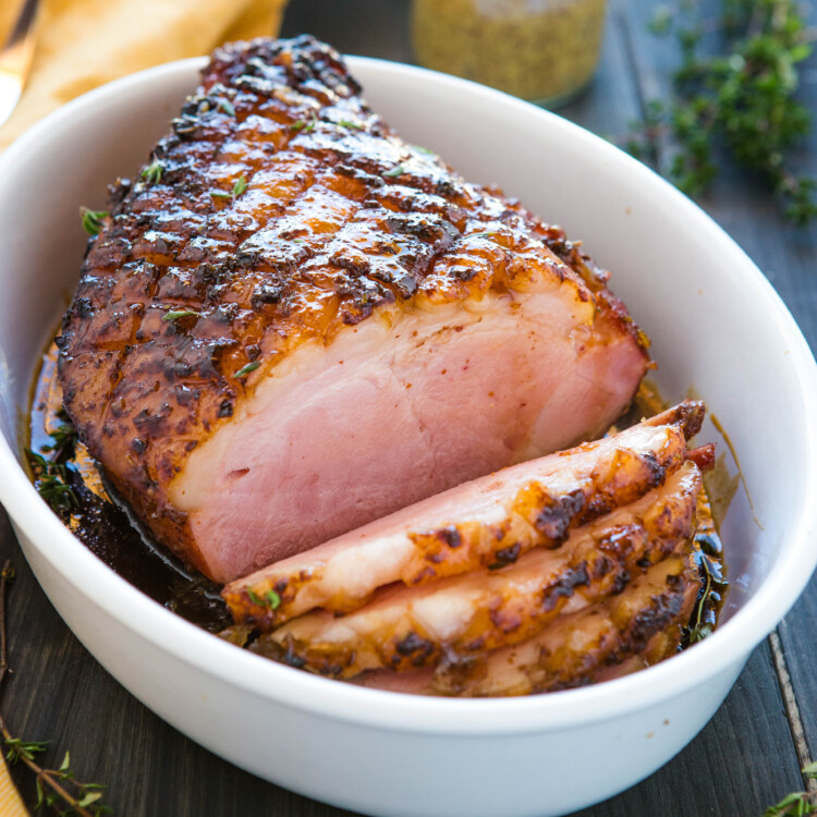 maple glazed ham in white dish, cut into slices