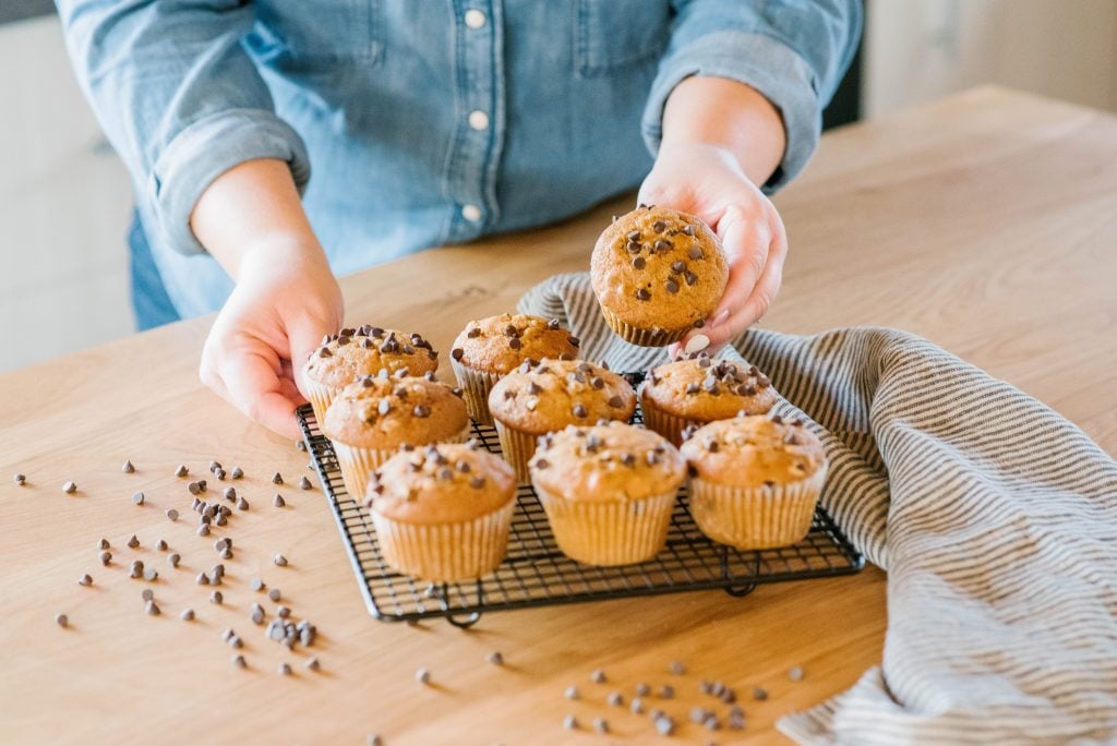 woman in kitchen with chocolate chip pumpkin muffins