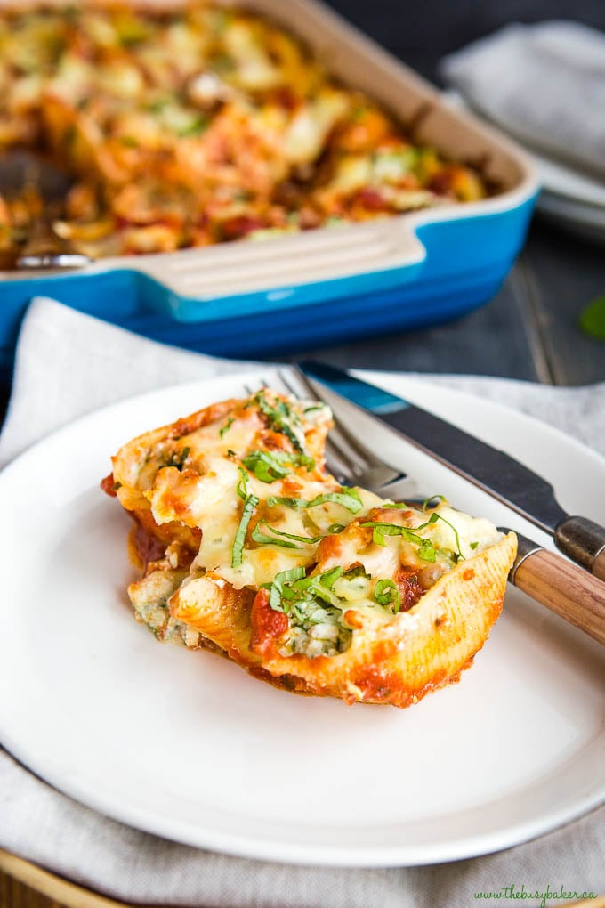 stuffed shells with ricotta on plate with fork and knife