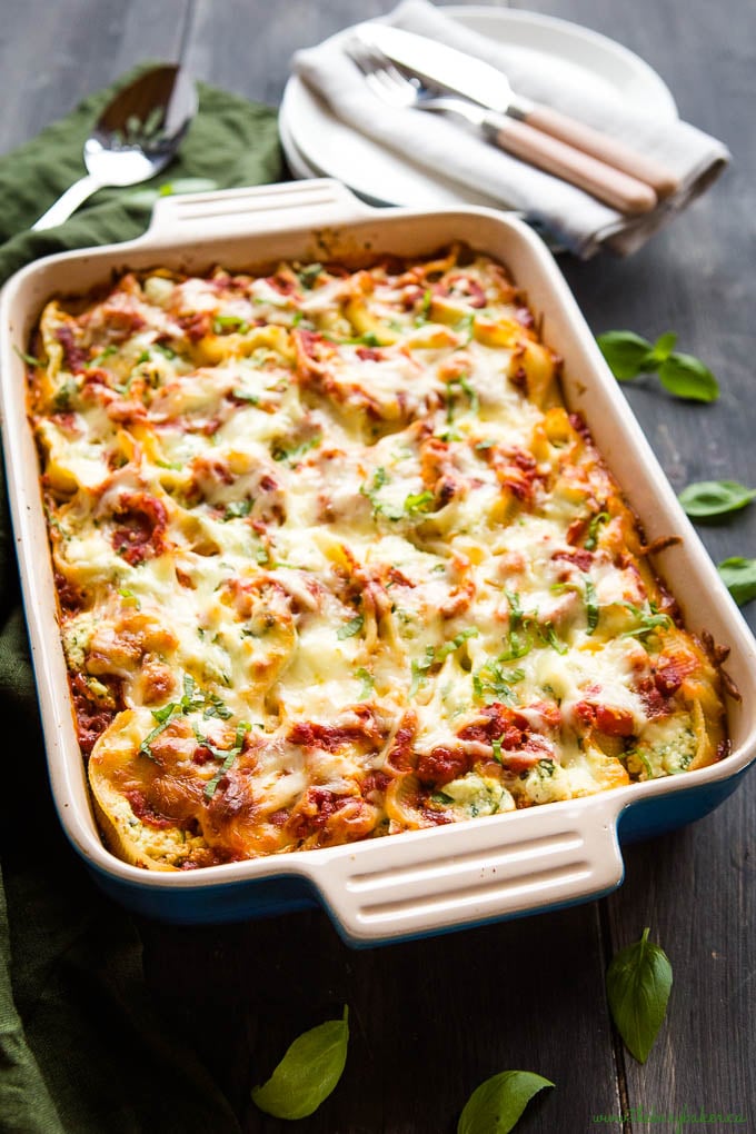 cheesy pasta dinner in casserole dish with fresh basil on top