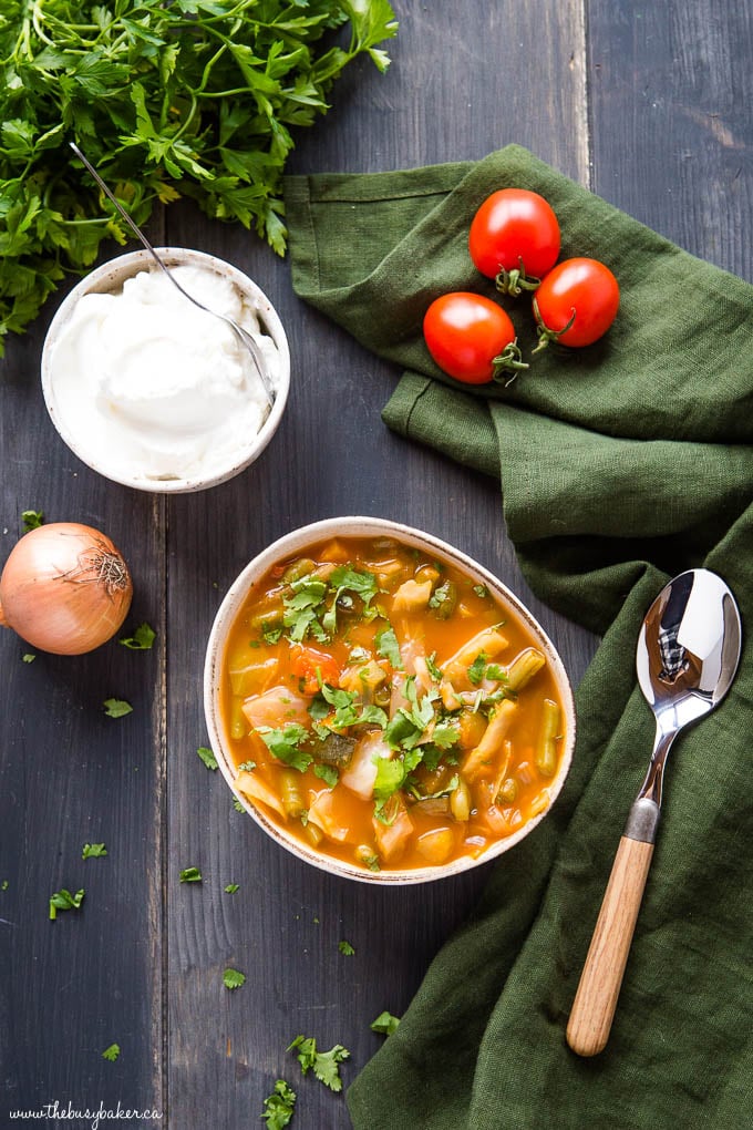 overhead photo - bowl of stew on table with spoon and green napkin