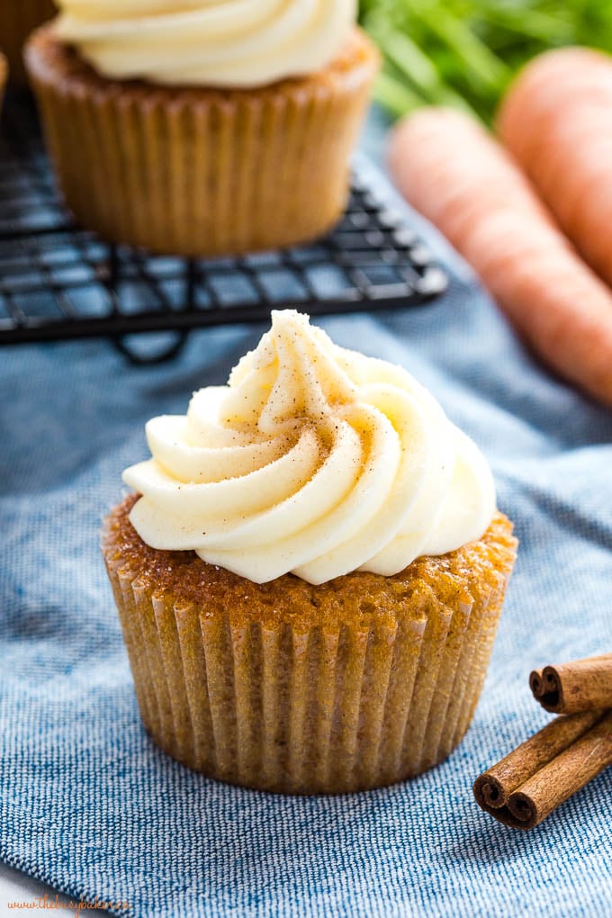 carrot cake cupcake with cream cheese frosting on blue background