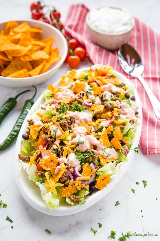 easy taco salad recipe topped with Doritos and creamy dressing