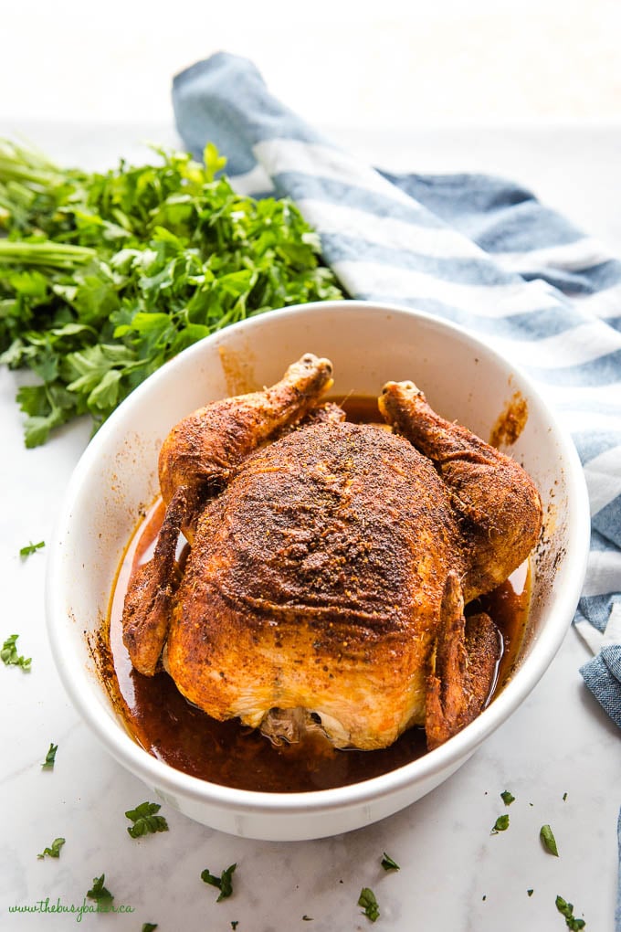 whole baked chicken with super crispy skin in white baking dish