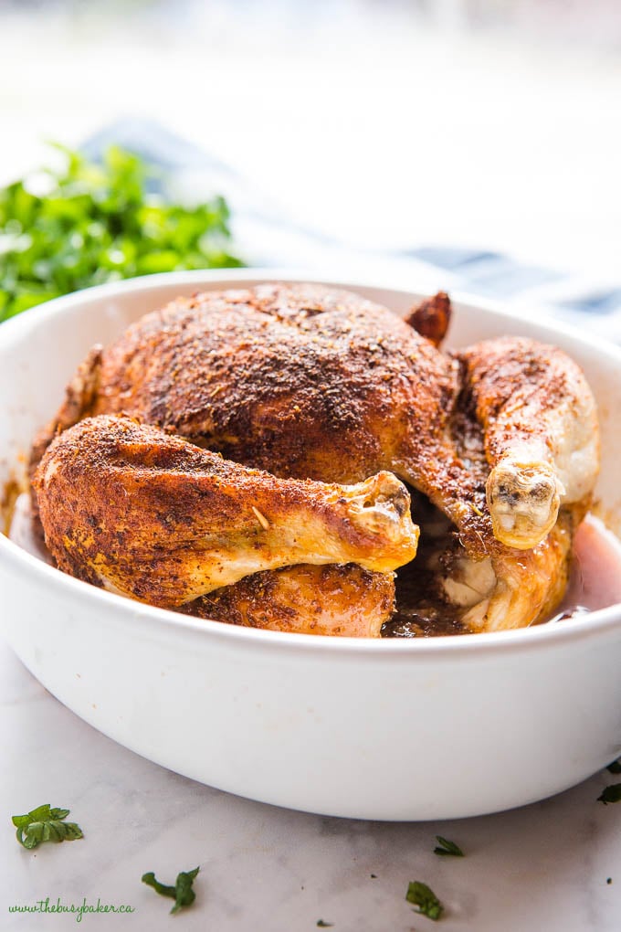 whole rotisserie chicken in white baking dish