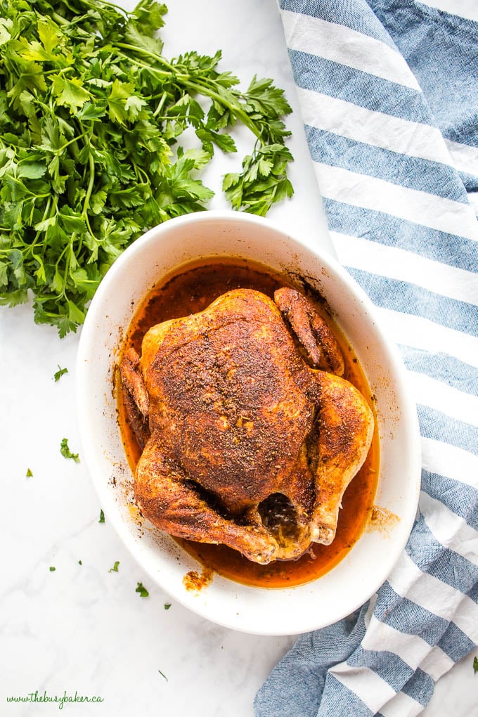 overhead photo: whole roasted chicken in white baking dish