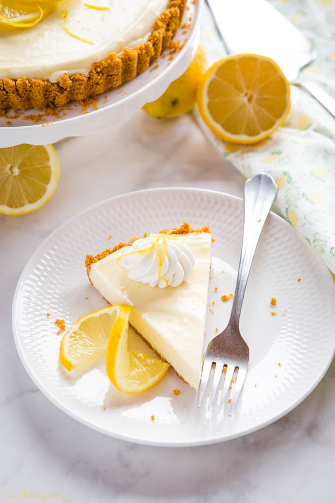 slice of lemon tart on white plate with lemon slices