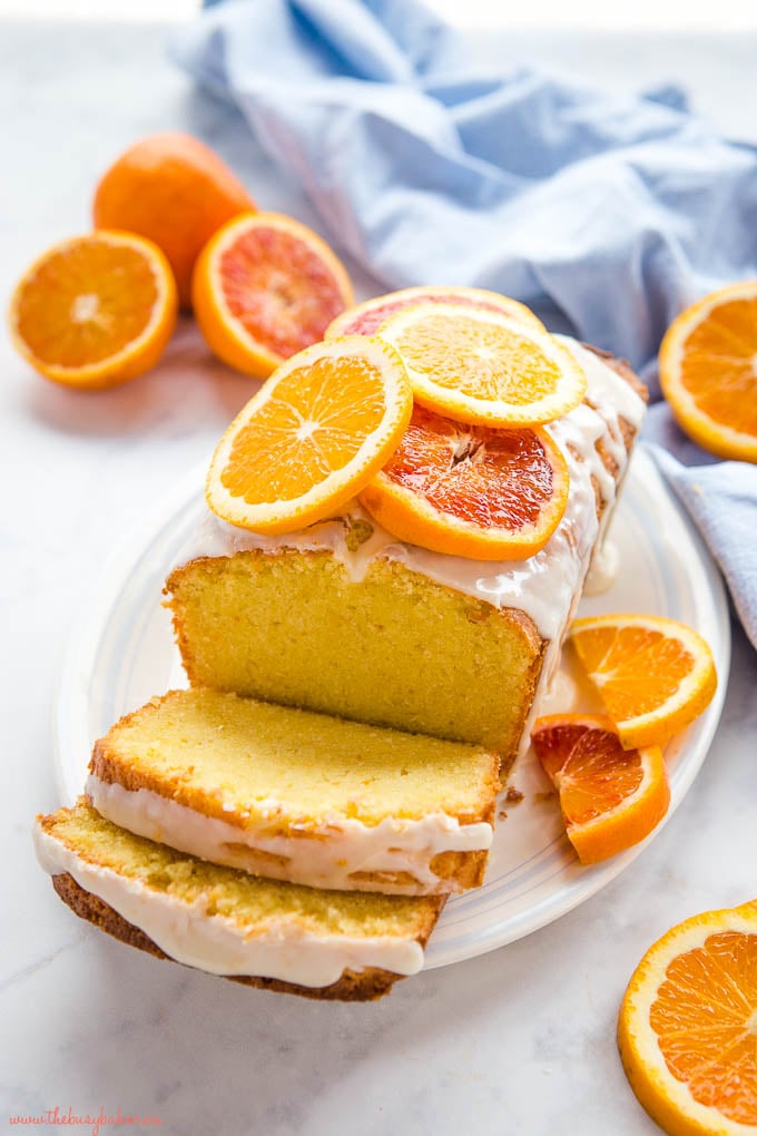 homemade sour cream loaf with white glaze and fresh citrus fruit slices on top