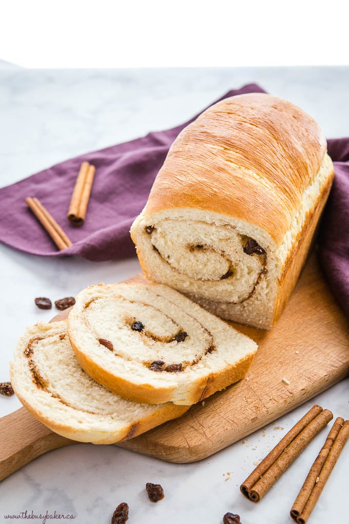 loaf of cinnamon raisin bread from scratch on cutting board with slices 