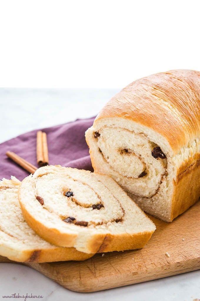 cinnamon raisin bread recipe, freshly baked and sliced, on cutting board