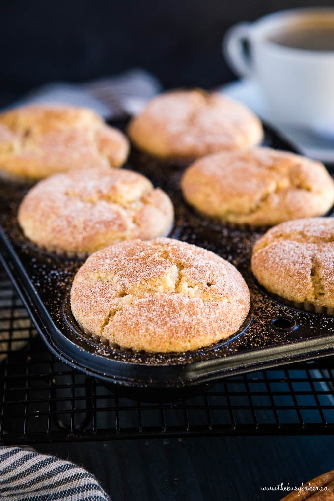 muffin tin full of fluffy moist muffins topped with cinnamon sugar