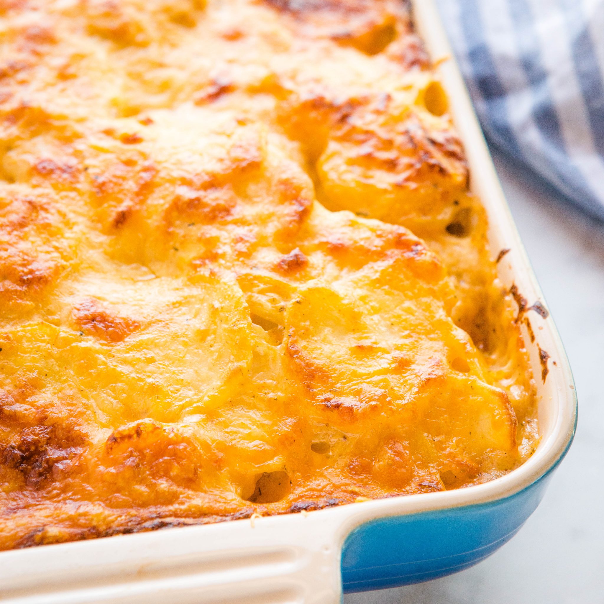 blue casserole dish of homemade scalloped potatoes