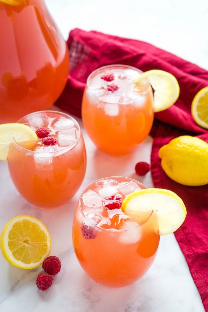 3 vasos de ponche de fiesta con cubitos de hielo y rodajas de limón