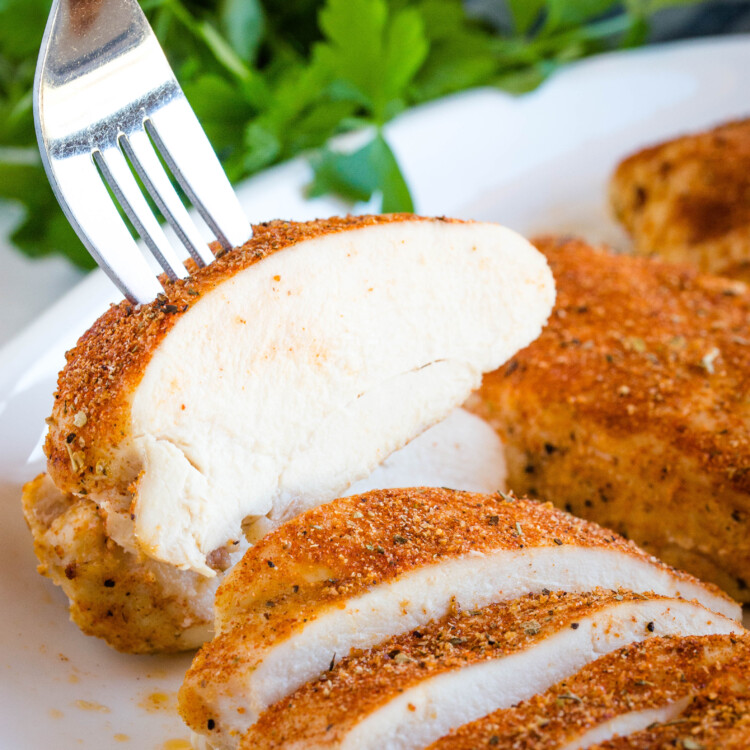 fork in slice of 5 spice oven baked chicken breast