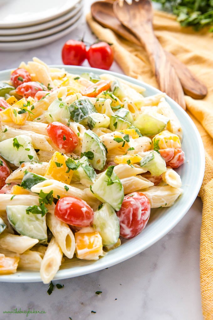 pasta salad with tomatoes and cucumbers in blue bowl