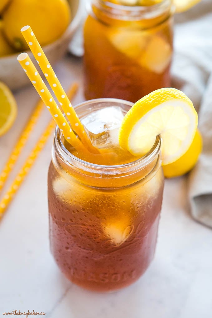 unsweetened tea in mason jar with ice and yellow straws
