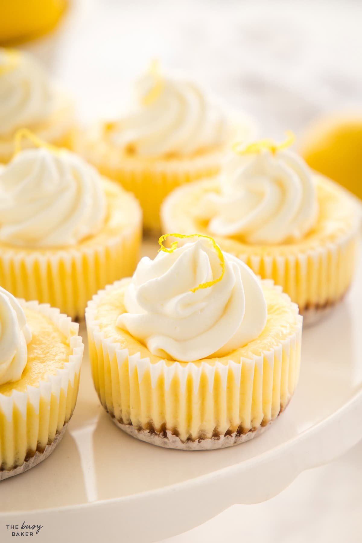 mini lemon cheesecake cups on a cake stand