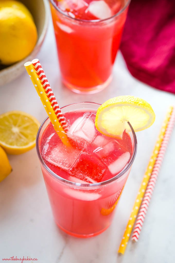 pink drink in glass with ice and lemon slices