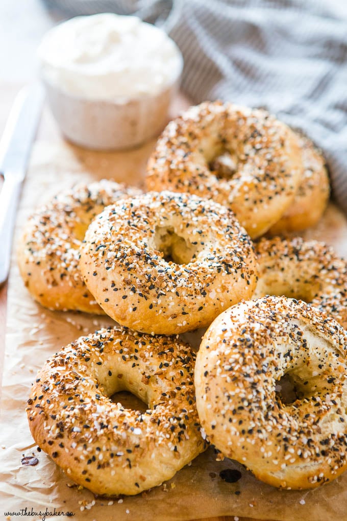 homemade everything bagels with everything bagel seasoning and cream cheese on parchment paper