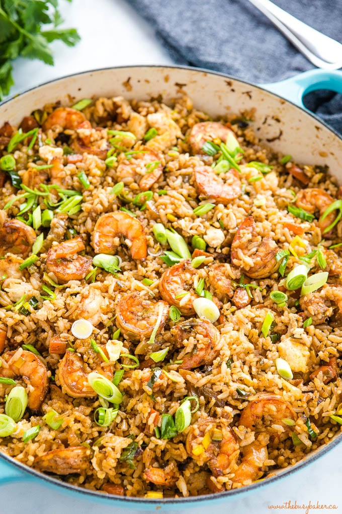shrimp fried rice with green onions in turquoise cast iron pan