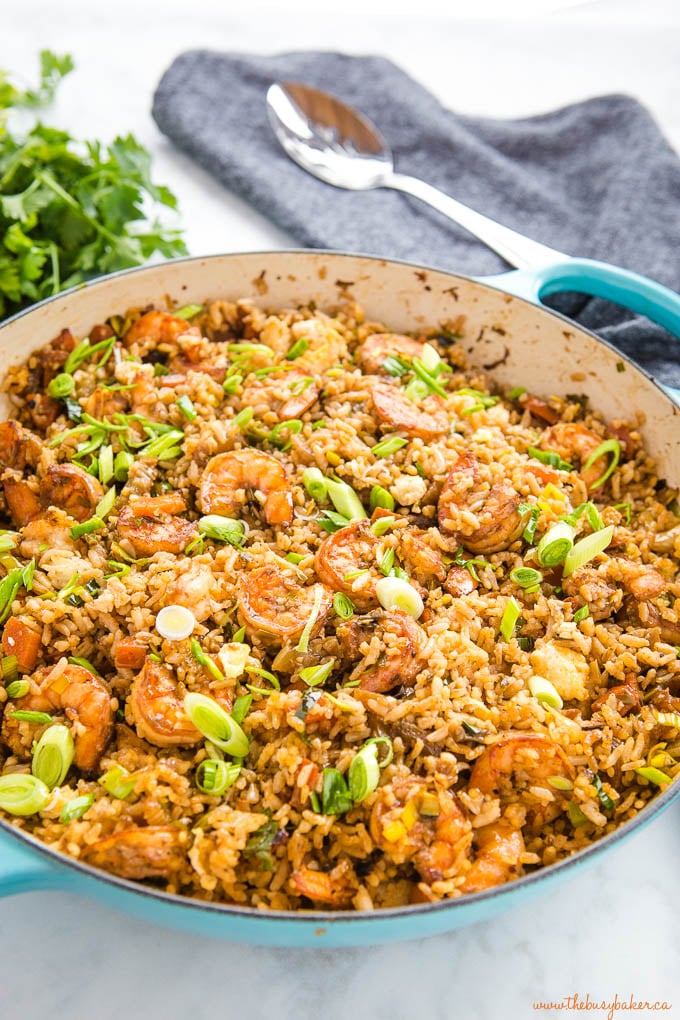 shrimp fried rice with green onions in cast iron pan with spoon