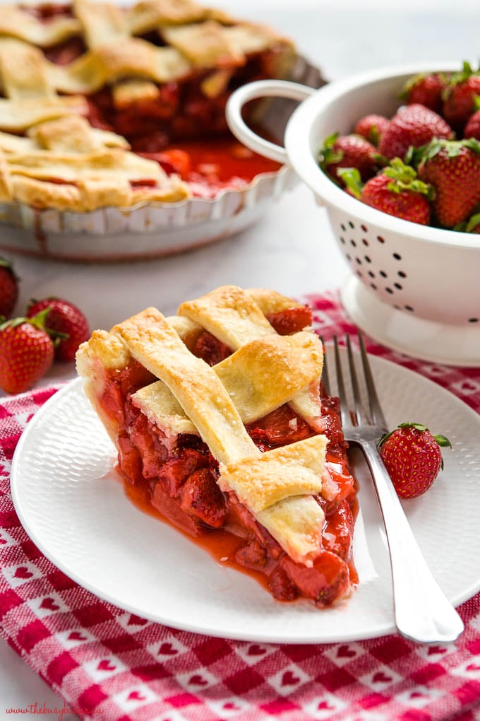 pie slice on white plate with a fork and strawberry