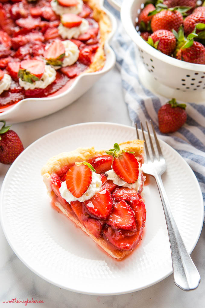 slice of fresh strawberry pie on white plate with fork