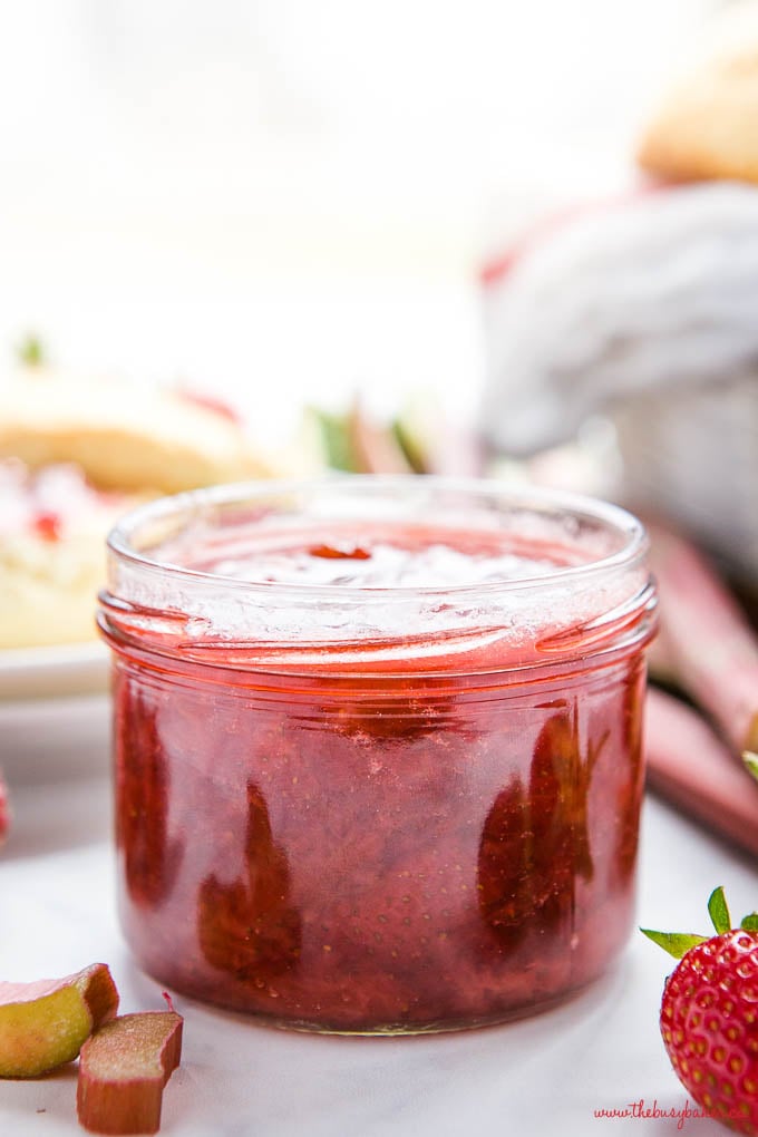 small jar of strawberry rhubarb jam with fresh strawberries and fresh rhubarb