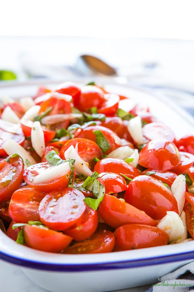 tomato onion salad with fresh basil in white and blue enamel bowl