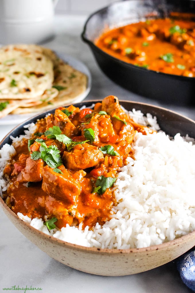 black speckled pottery bowl with rice and butter chicken with cilantro