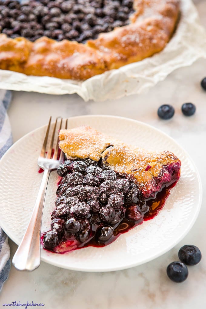 slice of blueberry galette on white plate with fork