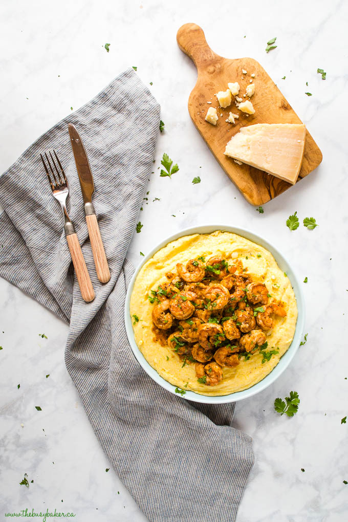 overhead image: blue bowl with creamy polenta and cajun shrimp with parmesan cheese