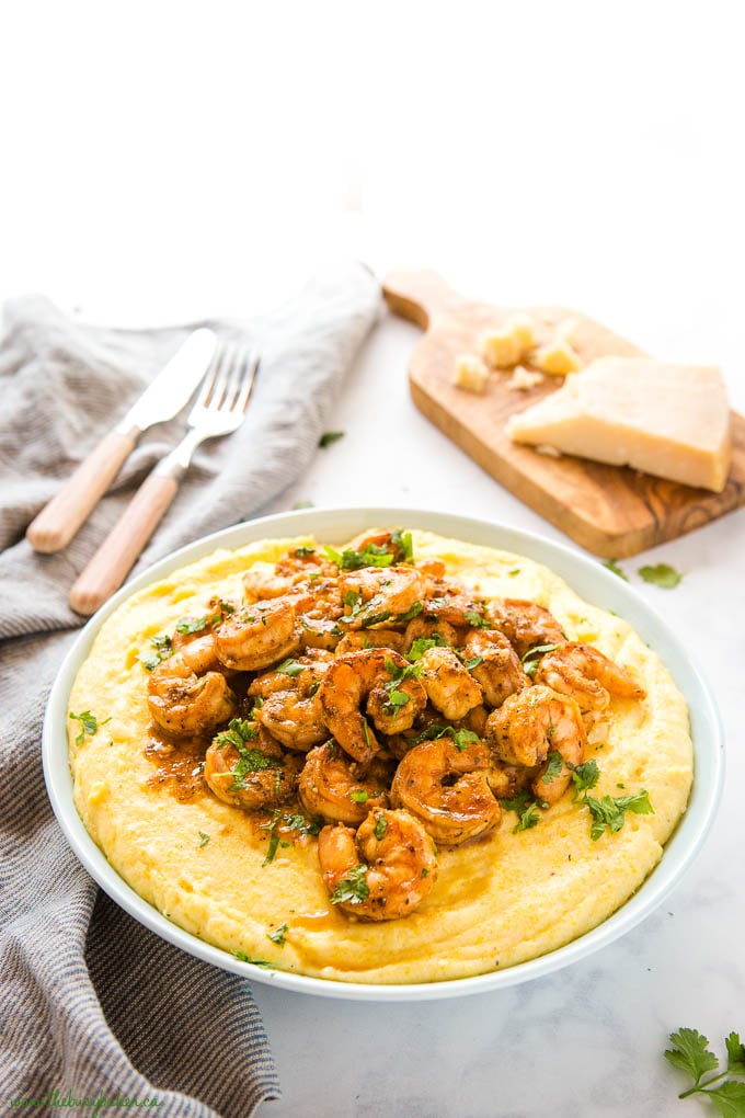 creamy polenta with cajun shrimp and fresh herbs in blue bowl