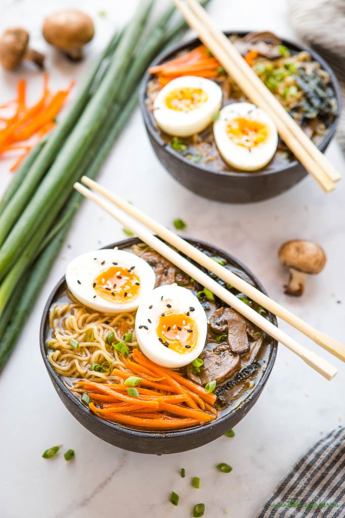 2 ramen bowls with chopsticks and green onions