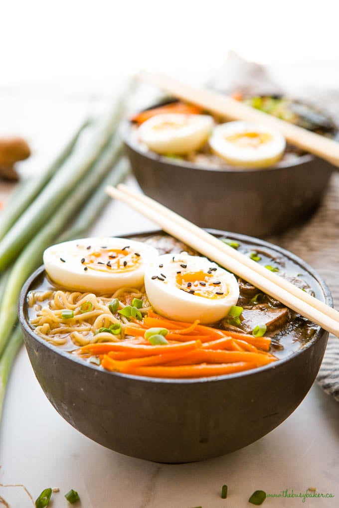 easy ramen bowl in black bowl with carrots, noodles, eggs, green onions, and sesame seeds