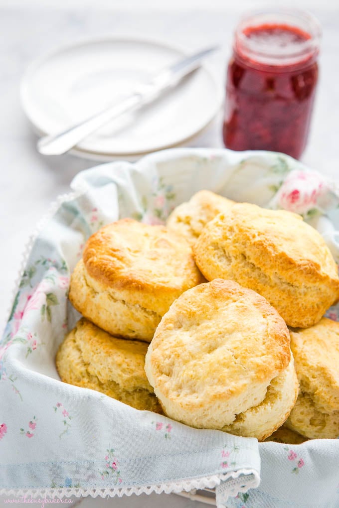 flaky scones in a basket with jam