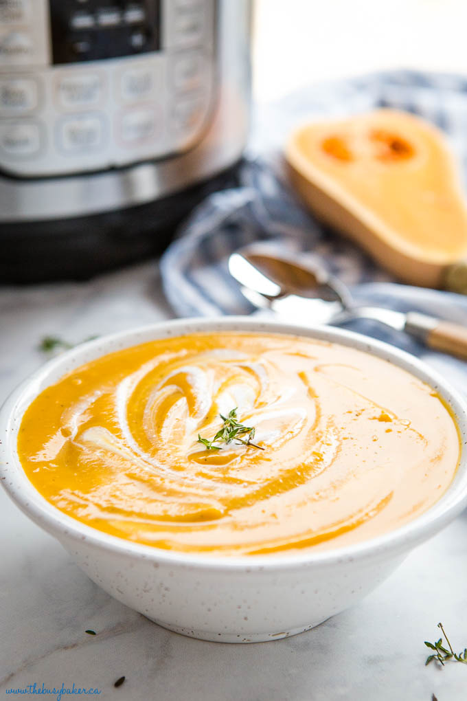 bowl of instant pot butternut squash soup with coconut cream and fresh thyme