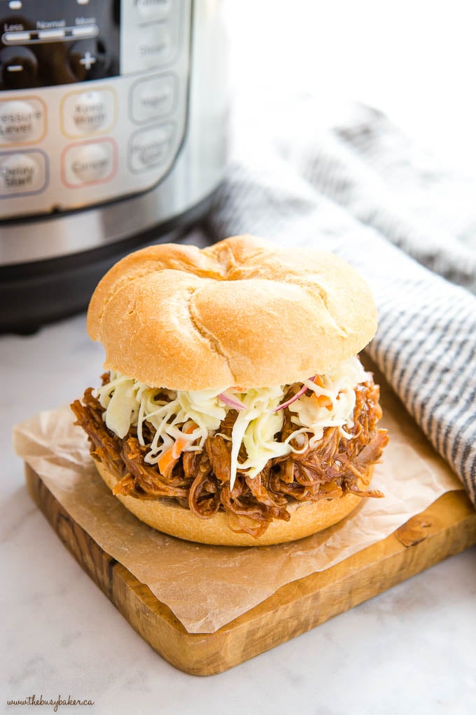 pulled pork on a white kaiser roll with coleslaw