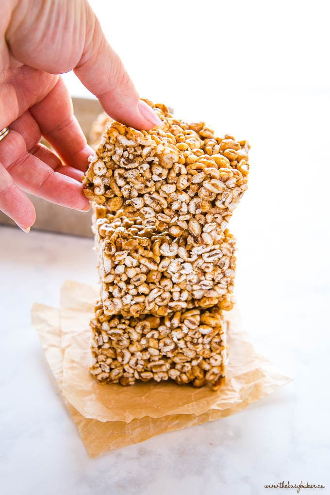 hand reaching for a piece of puffed wheat cake