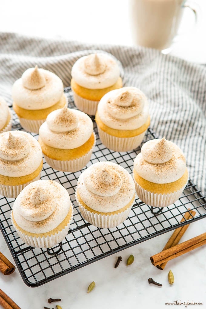 chai spice cupcakes on black wire rack with cinnamon sugar, cloves and cardamom