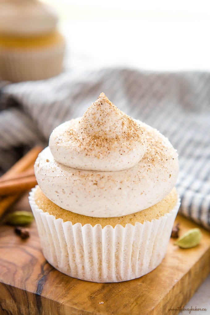 chai spice cupcake on wood board with cinnamon sugar and cardamom